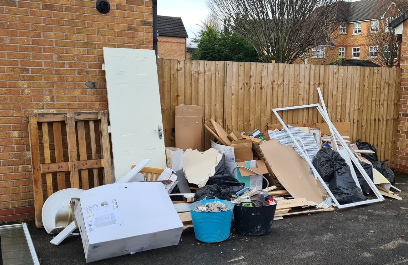 Pile of household bulky waste and DIY rubbish outside a UK home ready for collection