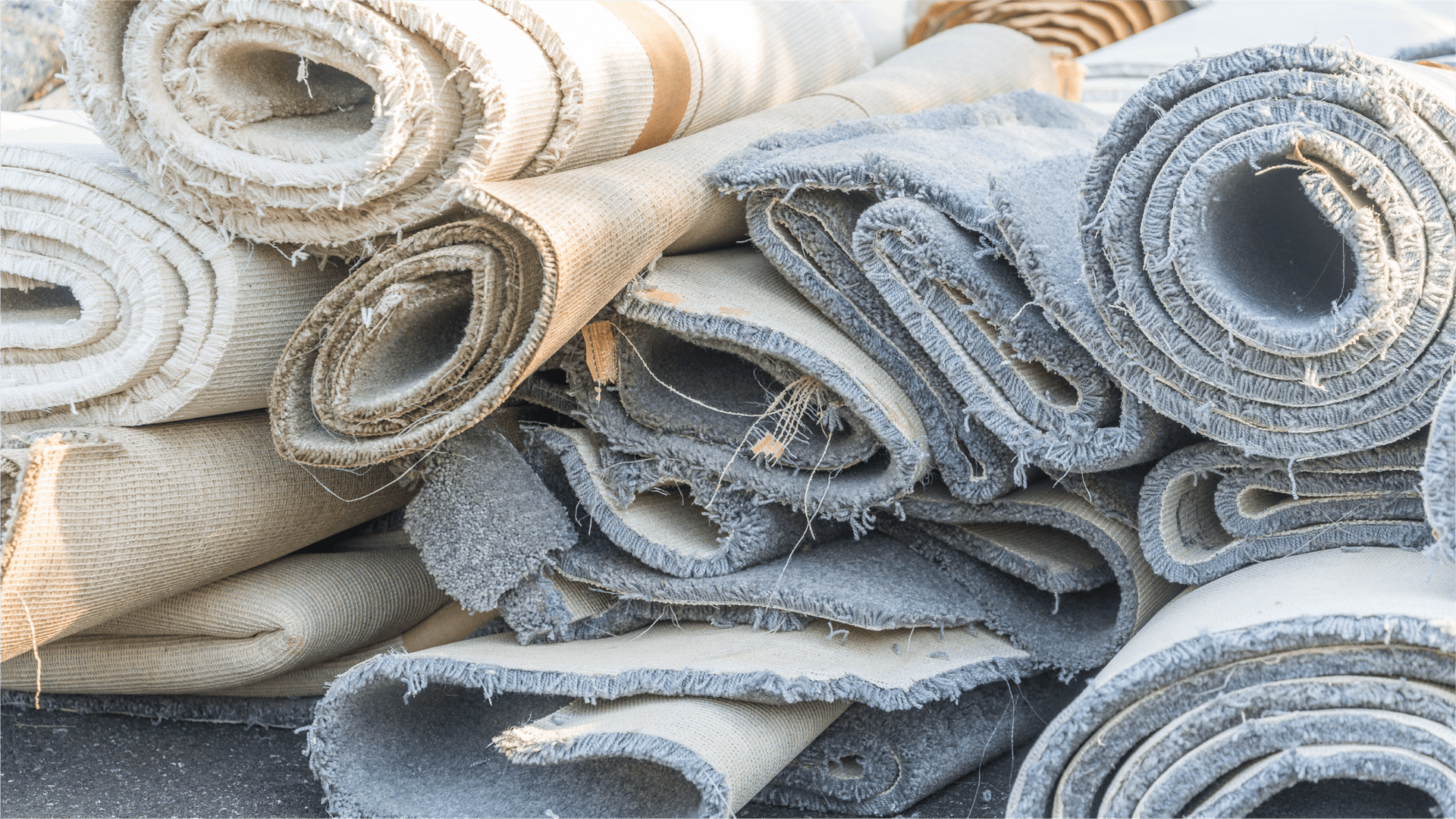 Rolled old carpets stacked together ready for recycling or disposal