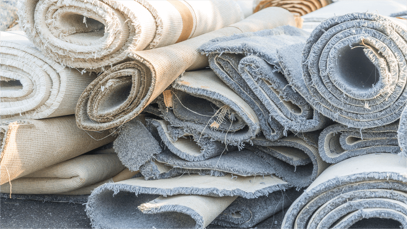 Rolled old carpets stacked together ready for recycling or disposal