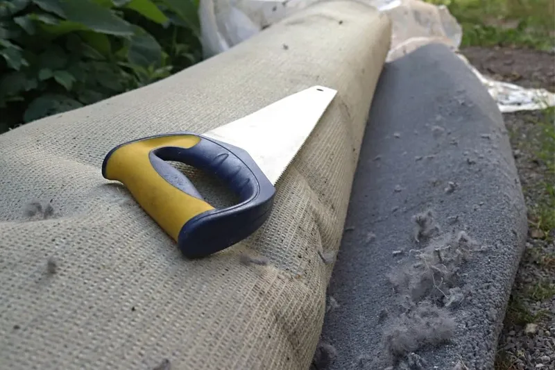 roll of old carpet for disposal near me with a saw on top