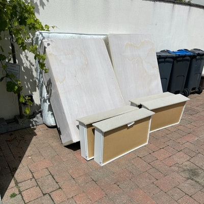 double bed and mattress near wheelie waste bin for collection